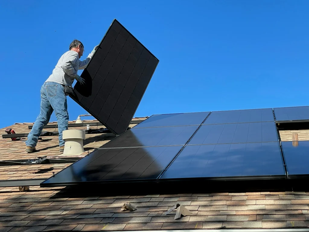 man lifting up solar panels in manchester